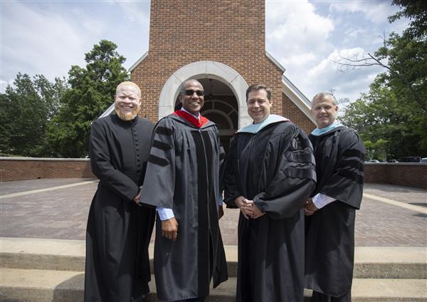 Donte Little; Bobby Humphrey; Dennis Gilliam, Ed.D.; and Andy Keith smile to camera from the front steps of Hawkins Chapel.